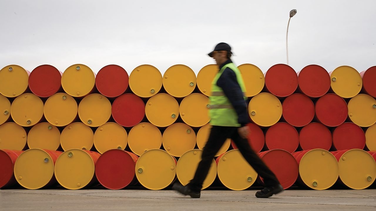 Homem andando na frente de barris