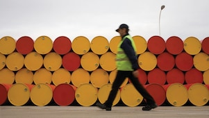 Homem andando na frente de barris