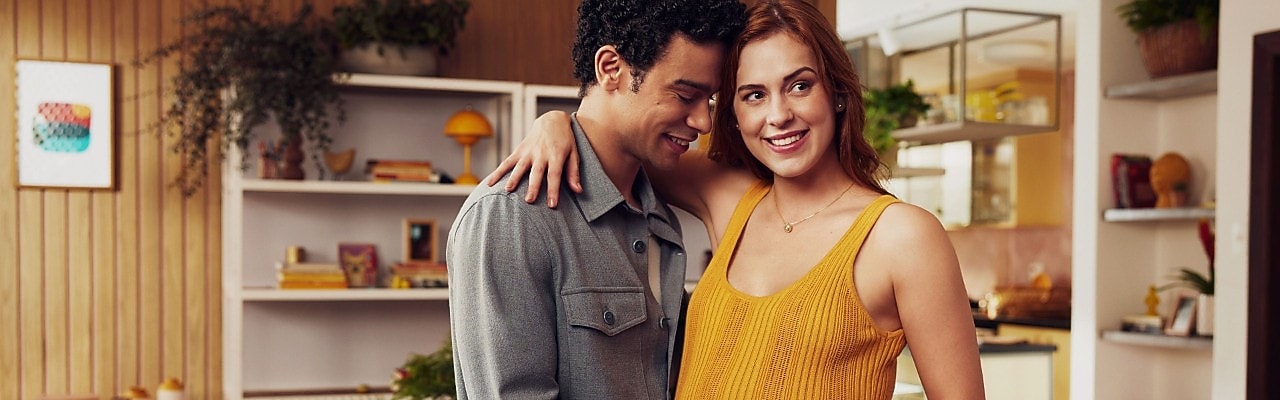 Um casal se abraça sorrindo.