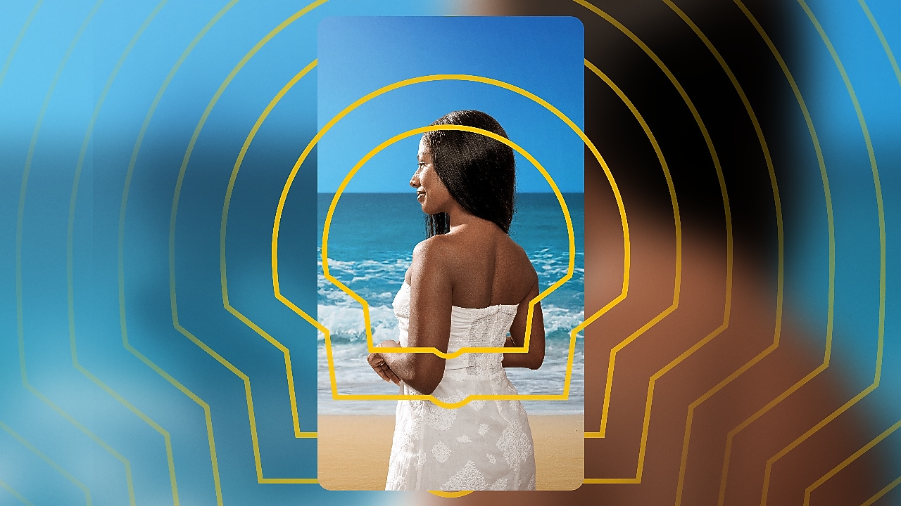 Uma mulher de pele negra olha para o mar.