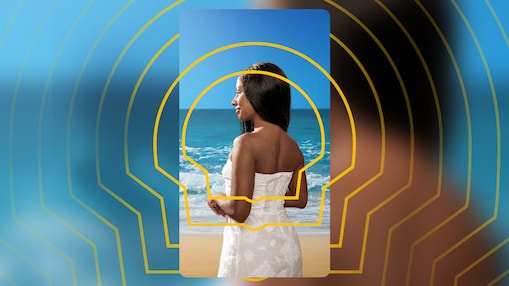 Uma mulher de pele negra olha para o mar.