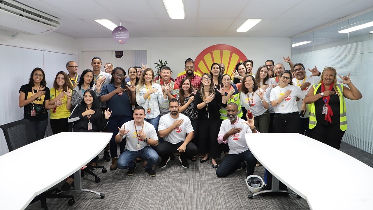 Em tom descontraído, participantes do primeiro treinamento de Libras da Shell fazem o sinal de “Shell, eu te amo”