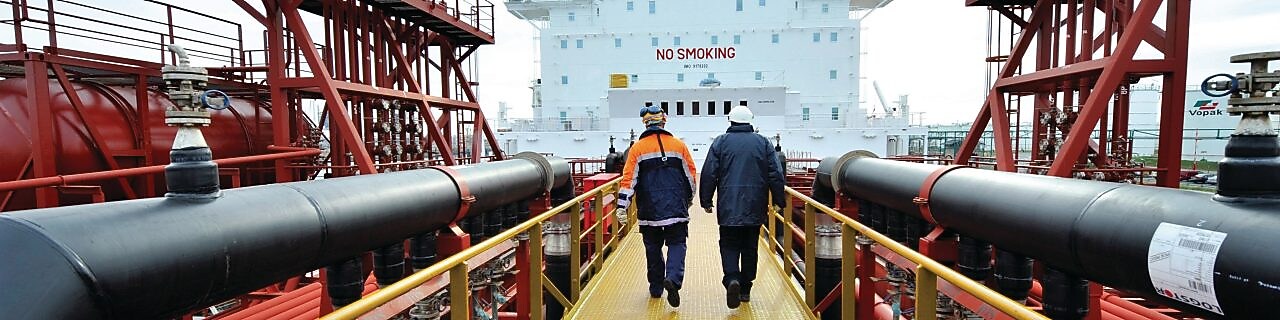 Funcionários da Shell caminham em refinaria de petróleo