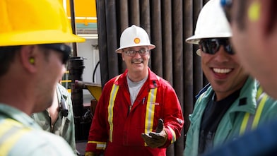 Um grupo de trabalhadores estão reunidos e sorrindo, em um momento de descontração