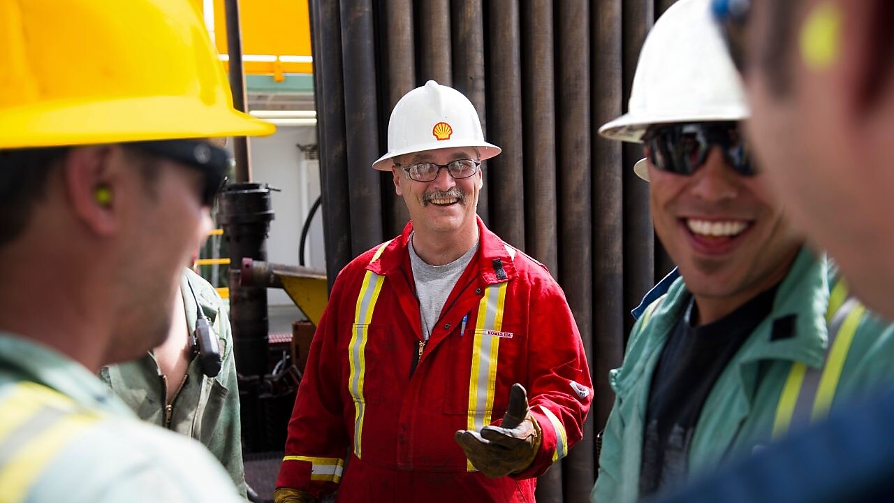 Um grupo de trabalhadores estão reunidos e sorrindo, em um momento de descontração