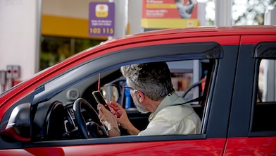 Motorista dentro do carro realizando pagamento de abastecimento com Shell Box