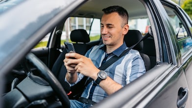 Homem dentro de carro estacionado utilizando o app no posto