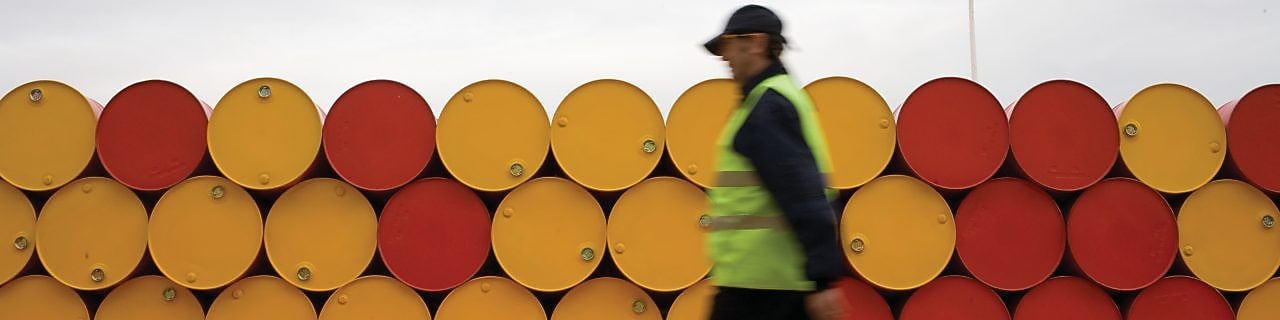 Homem andando na frente de barris