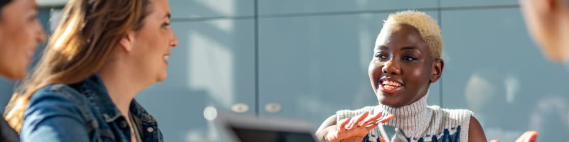 Um grupo de profissionais, de diferentes etnias, participa de uma reunião com laptops em ambiente de trabalho