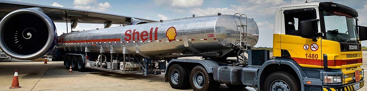 Caminhão de abastecimento da Shell em frente a um avião