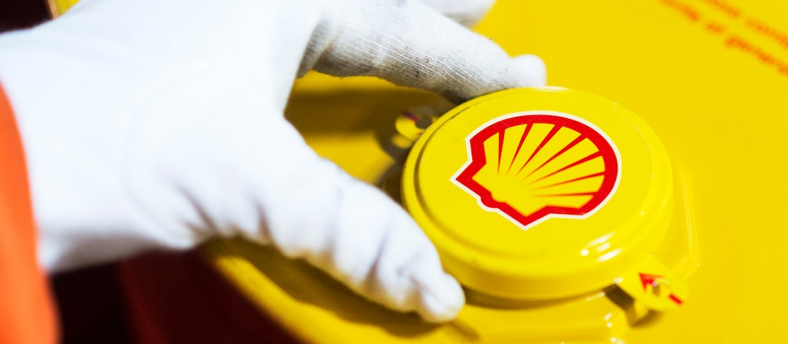 Imagem mostra mão de uma pessoa com luva abrindo recipiente com lubrificante Shell