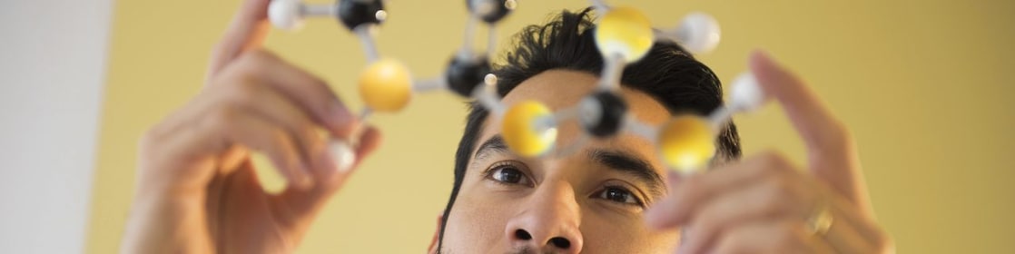 Homem jovem examinando modelo molecular
