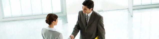 Homem e mulher de negócios apertando as mãos em um lobby