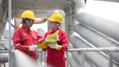 two workers discussing a project in a refinery in Malaysia
