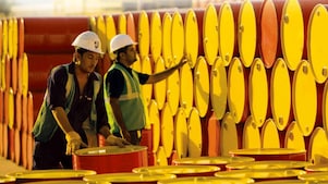 dois funcionários transportando barris da Shell