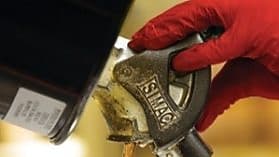 Trabalhador retirando produto químico de contêiner