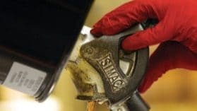 Trabalhador retirando produto químico de contêiner