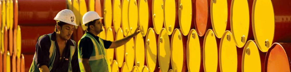 dois funcionários transportando barris da Shell