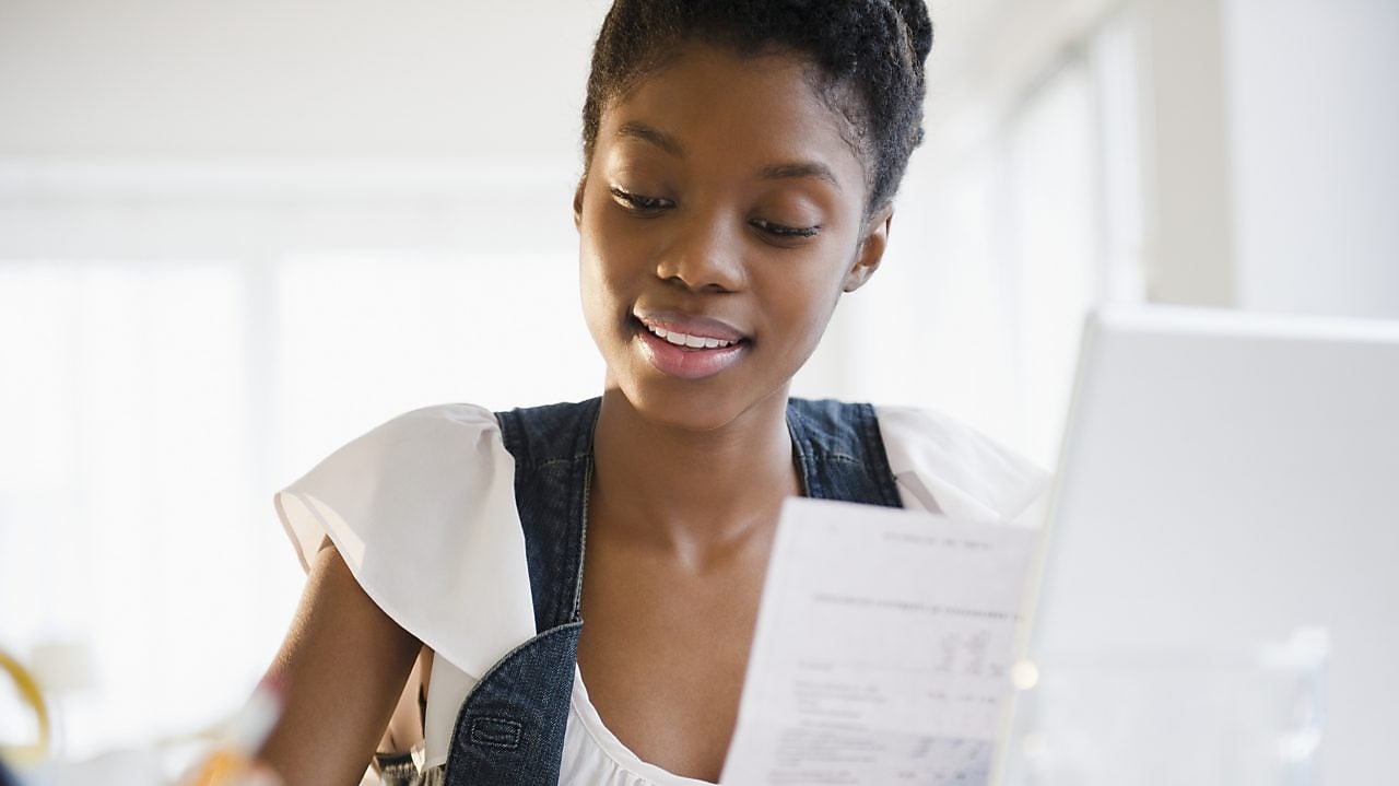 Pessoa sentada em frente a um laptop, participando de uma avaliação online, com a tela exibindo perguntas e gráficos.