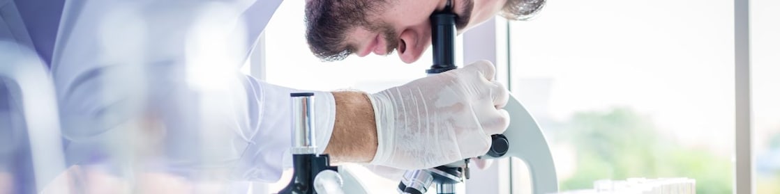 Scientist using microscope in lab