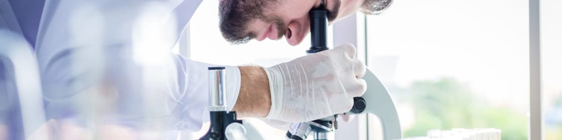 Scientist using microscope in lab