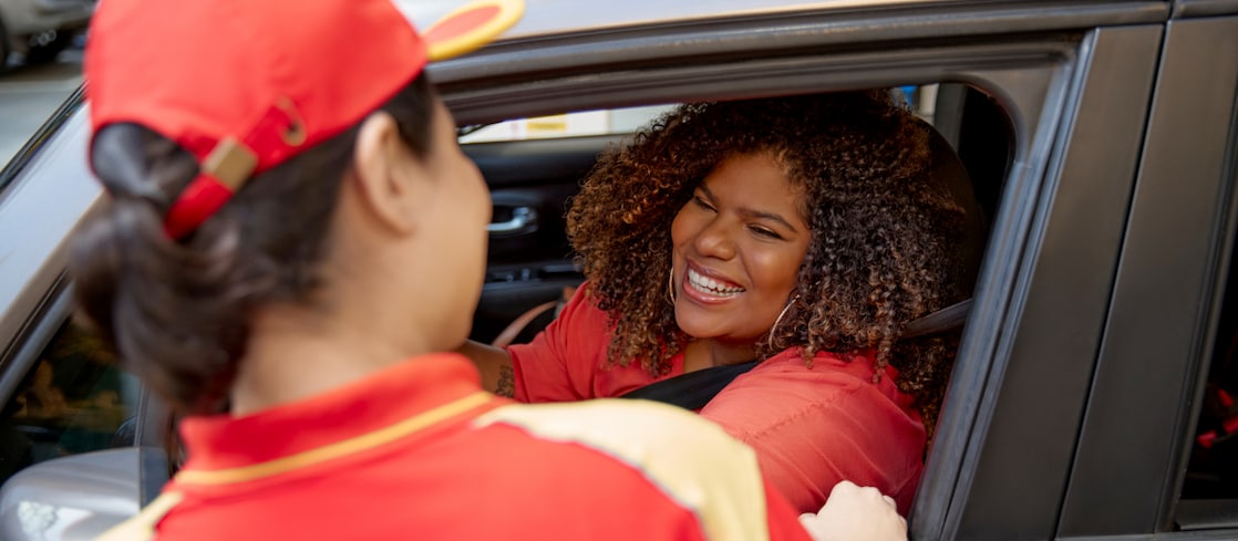 Mulher dentro de um carro conversando com frentista