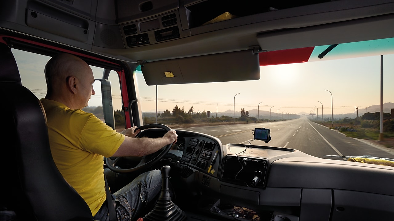 Caminhoneiro dirige em uma longa estrada