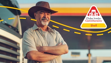 Homem de frente com estrada e caminhão ao fundo e logo do Clube aplicada sobre imagem