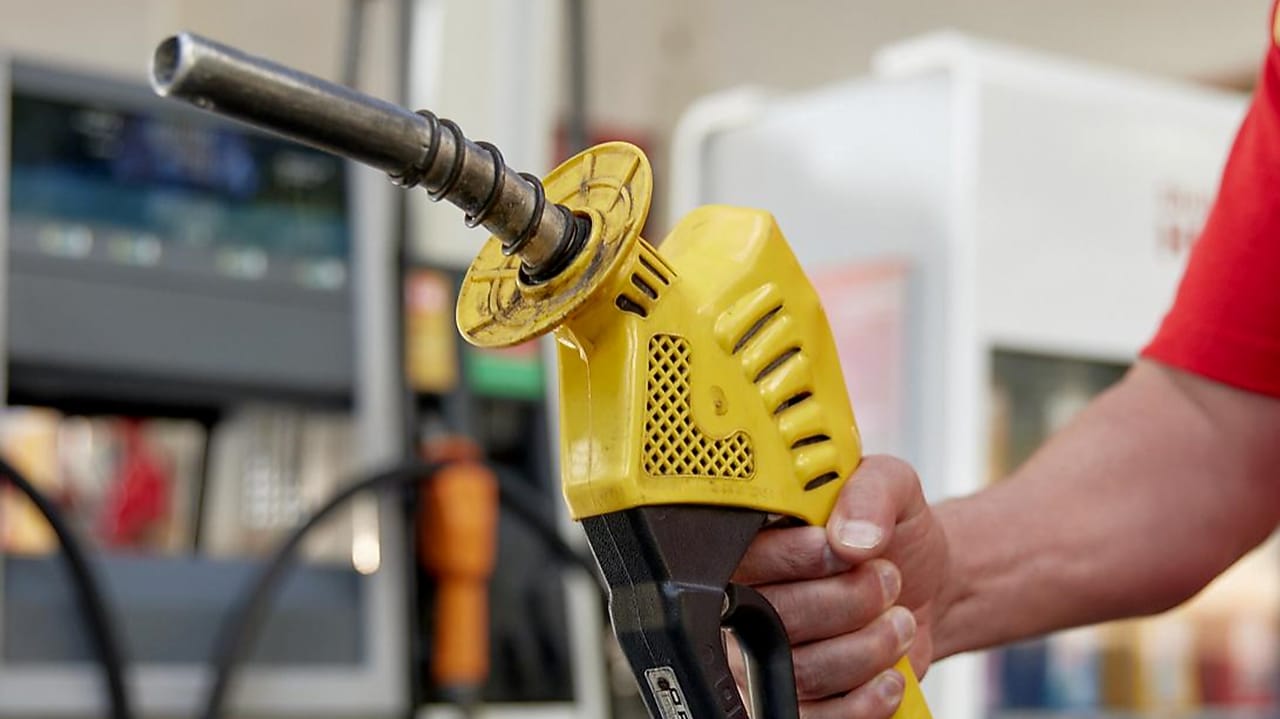 Mão segurando bomba de combustível na cor amarela