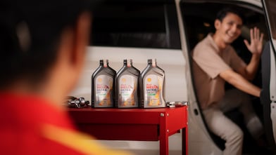 Pessoa saindo do carro e, ao lado do carro, opções de lubrificantes Shell para carros