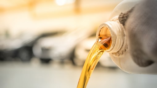 Cientista vestindo luvas amarelas e óculos de laboratório examina substância em tubo de ensaio