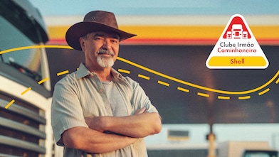 Homem de frente com estrada e caminhão ao fundo e logo do Clube aplicada sobre imagem