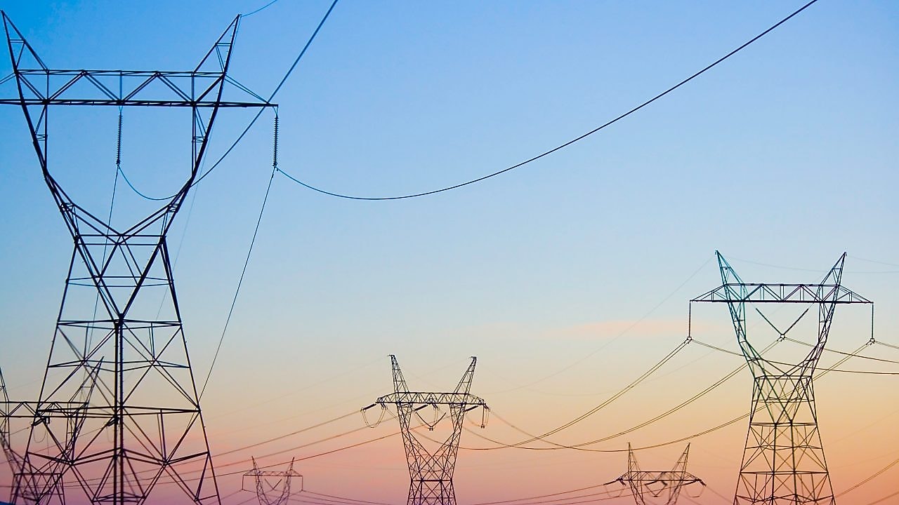 Paisagem ao pôr do sol com rede de distribuição de energia em destaque