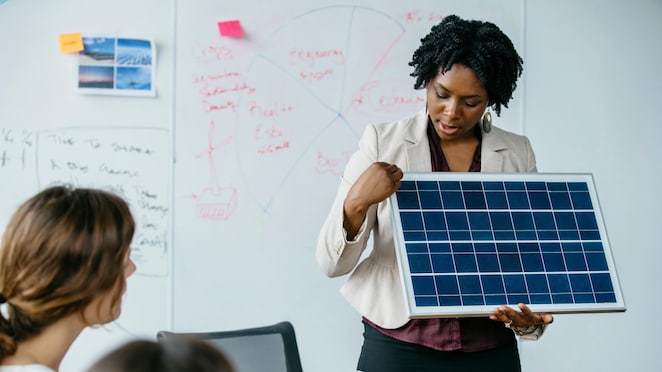 Empresária explicando o modelo de painel solar durante reunião em escritório