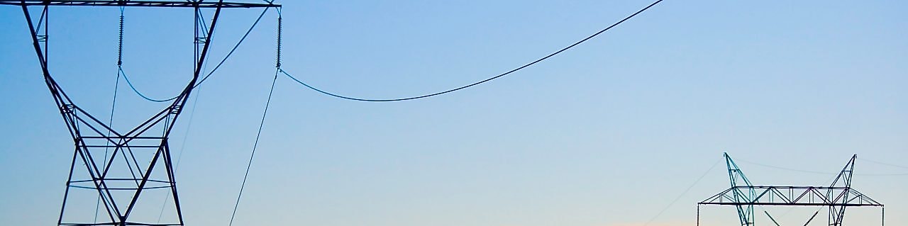 Paisagem ao pôr do sol com rede de distribuição de energia em destaque