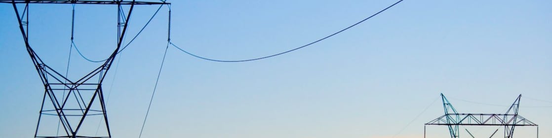 Paisagem ao pôr do sol com rede de distribuição de energia em destaque