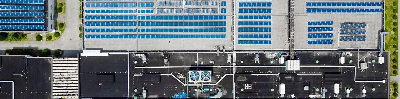 Uma visão aérea de um conjunto de prédios com painéis solares instalados no telhado