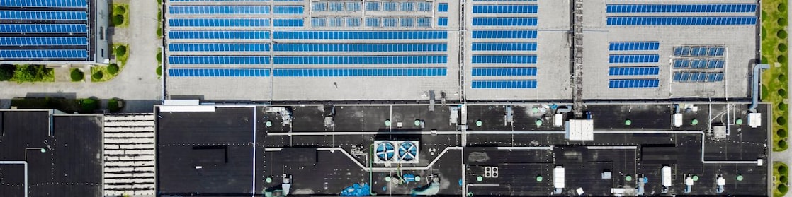 Uma visão aérea de um conjunto de prédios com painéis solares instalados no telhado
