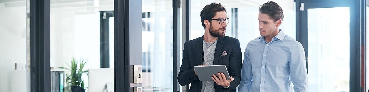 Foto de dois empresários usando um tablet digital juntos em um escritório