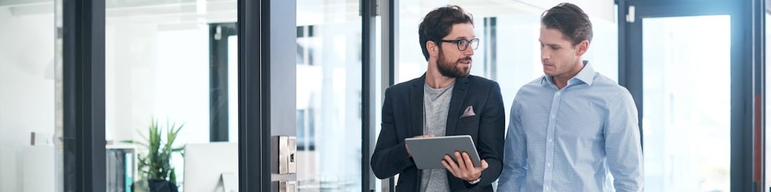 Foto de dois empresários usando um tablet digital juntos em um escritório