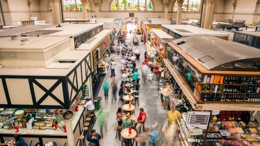 Pessoas trabalhando, fazendo compras e comendo dentro do Mercado Municipal em São Paulo, Brasil.