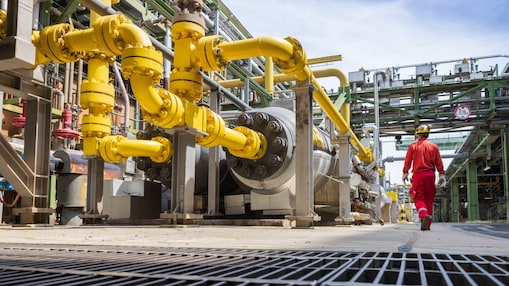 Indivíduo caminhando e observando aparelho em parque químico