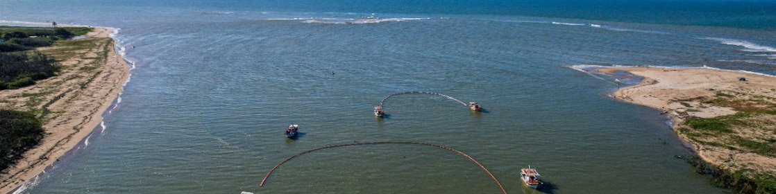 Seis barcos simulando a técnica de limpeza utilizada em situações de incidentes com vazamento de óleo no mar.