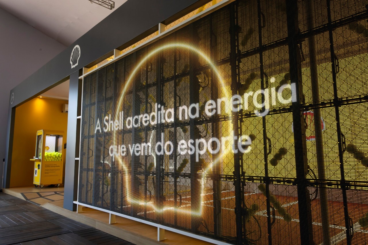 Instalação temática da Shell com iluminação em formato de cérebro e a frase ‘A Shell acredita na energia que vem do esporte’ projetada na estrutura.