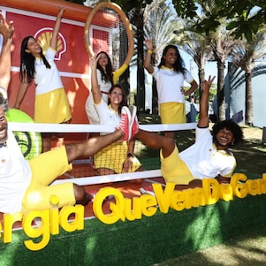 Instalação visual iluminada mostra o desenho de um cérebro com o logotipo da Shell ao centro, enquanto silhuetas de pessoas caminham ao fundo.