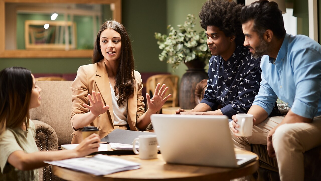 Quatro pessoas sentadas, olhando umas as outras  e conversando