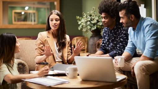Quatro pessoas sentadas, olhando umas as outras  e conversando
